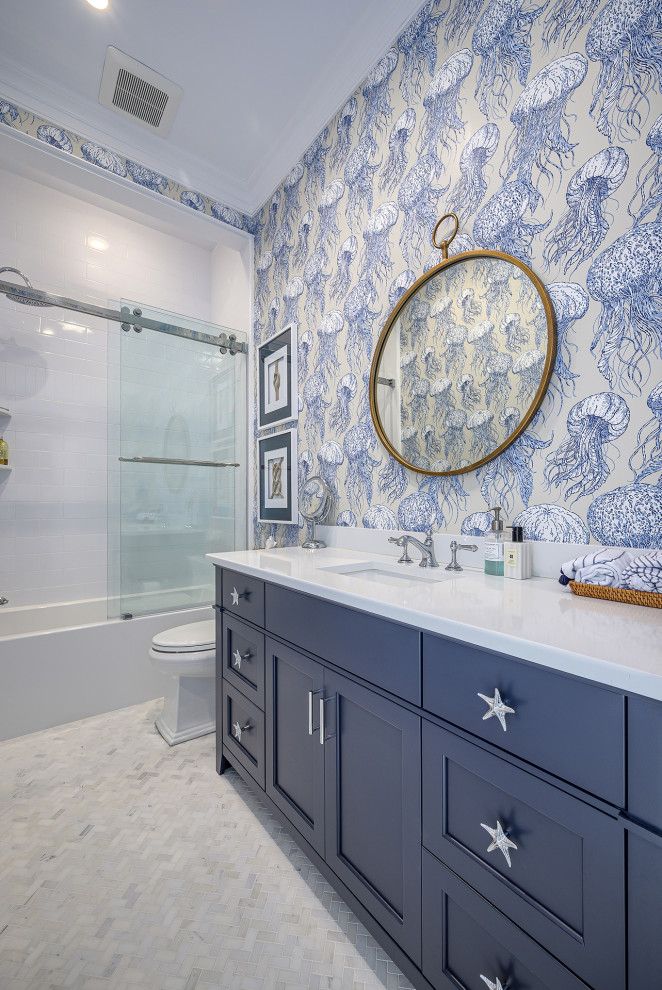 Источник вдохновения для домашнего уюта: ванная комната в морском стиле с фасадами в стиле шейкер, синими фасадами, душем над ванной, унитазом-моноблоком, синими стенами, полом из керамической плитки, накладной раковиной, столешницей из кварцита, серым полом, душем с раздвижными дверями, белой столешницей, тумбой под одну раковину, напольной тумбой и обоями на стенах