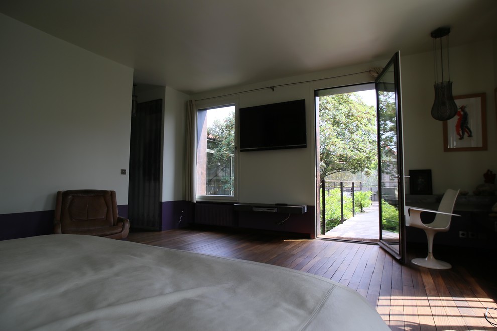 Photo of a midcentury bedroom in Paris with medium hardwood floors.