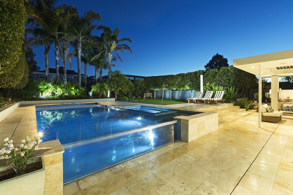 Mid-sized traditional backyard custom-shaped pool in Melbourne with natural stone pavers.