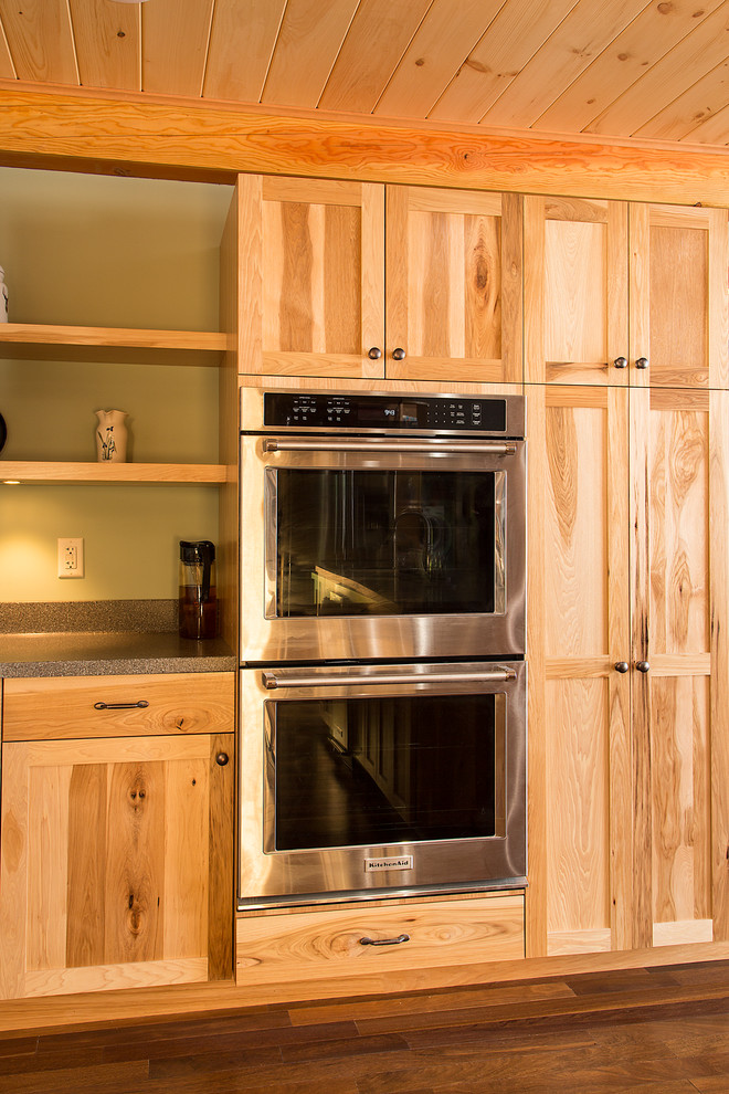 Large mountain style u-shaped dark wood floor eat-in kitchen photo in Burlington with an undermount sink, shaker cabinets, medium tone wood cabinets, solid surface countertops, an island and stainless steel appliances