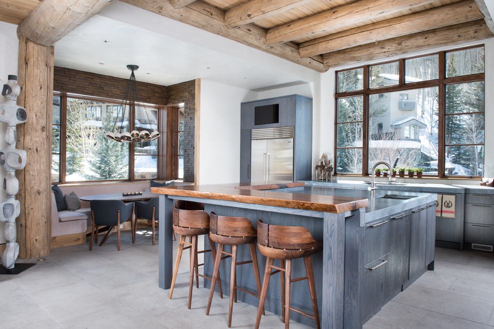 Inspiration for a large modern l-shaped eat-in kitchen in Denver with an undermount sink, flat-panel cabinets, grey cabinets, concrete benchtops, window splashback, stainless steel appliances, with island, grey floor and grey benchtop.