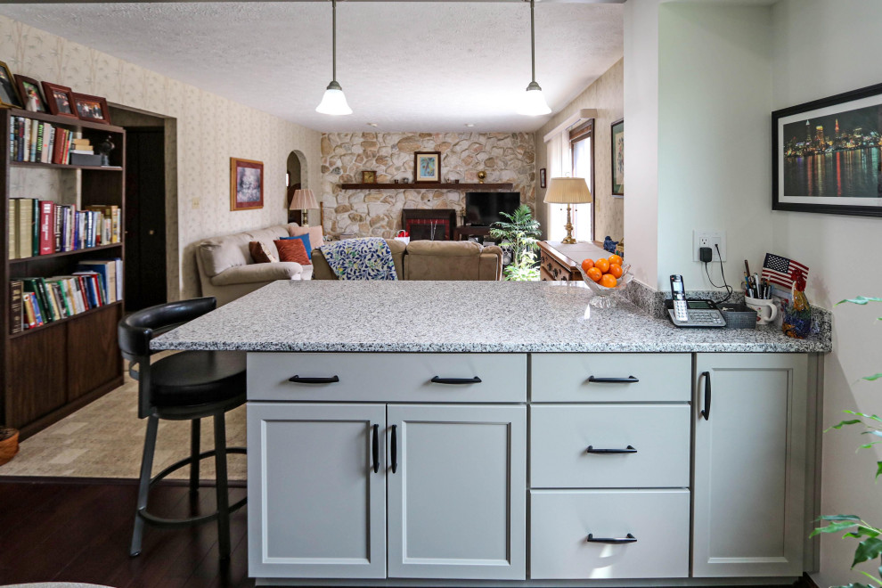 Photo of a mid-sized transitional galley eat-in kitchen in Cleveland with an undermount sink, flat-panel cabinets, grey cabinets, granite benchtops, beige splashback, glass tile splashback, stainless steel appliances, a peninsula and multi-coloured benchtop.