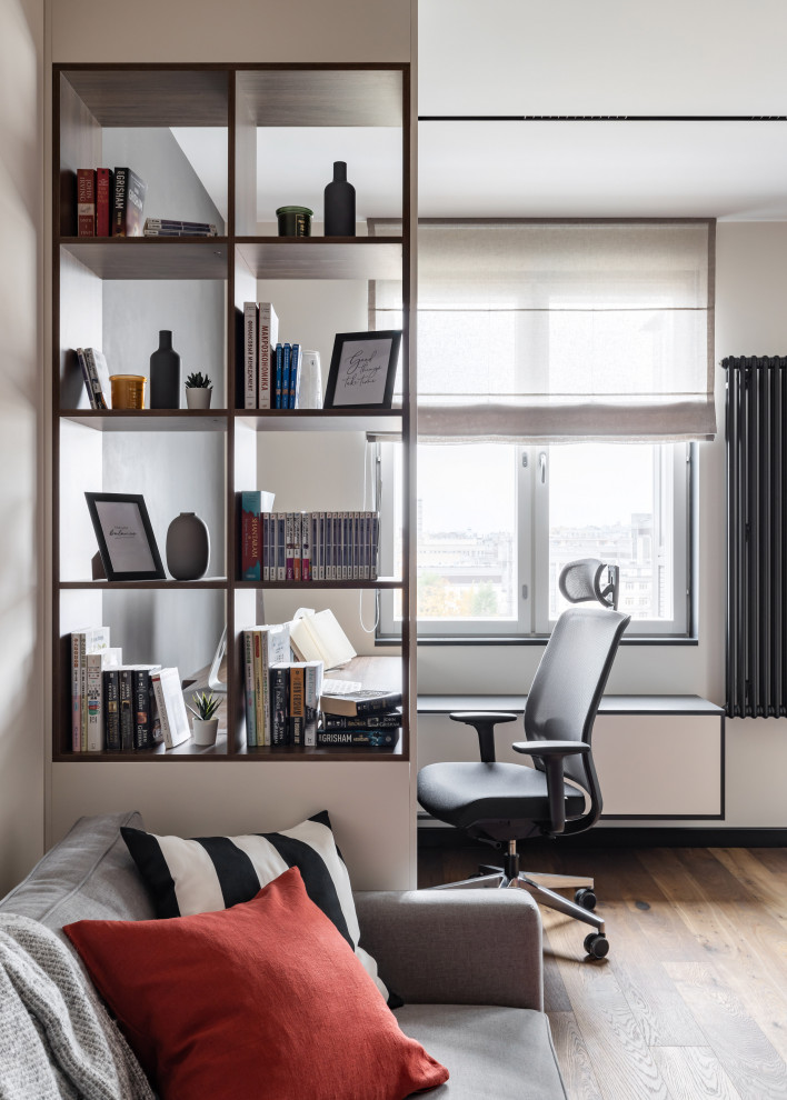 Photo of a small contemporary home office in Saint Petersburg with a library, grey walls and a built-in desk.