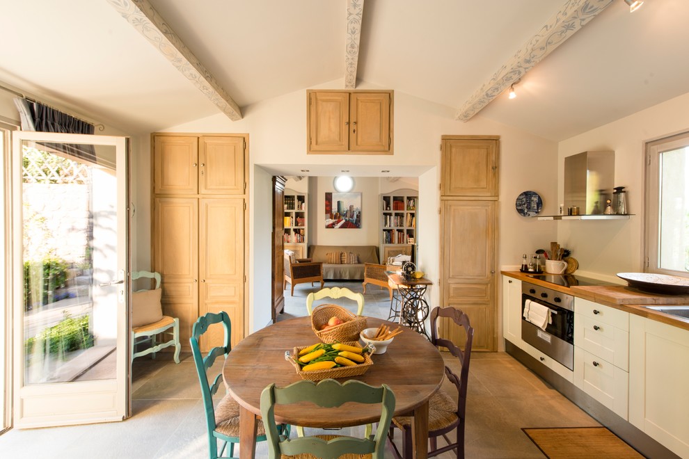 Design ideas for a mid-sized country kitchen/dining combo in London with white walls.