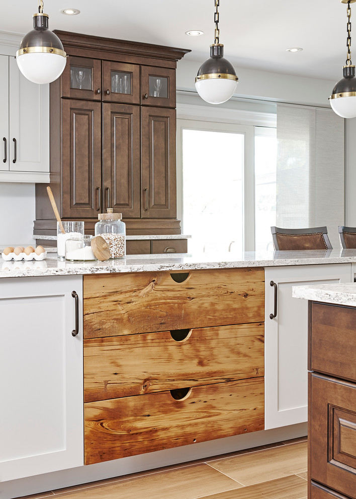 Example of a large transitional l-shaped ceramic tile eat-in kitchen design in Toronto with an undermount sink, raised-panel cabinets, dark wood cabinets, quartz countertops, gray backsplash, stone slab backsplash, paneled appliances and an island