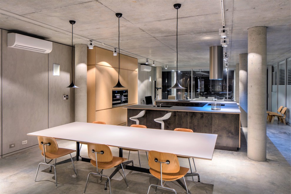 This is an example of an industrial open plan dining in Perth with grey walls, concrete floors and grey floor.