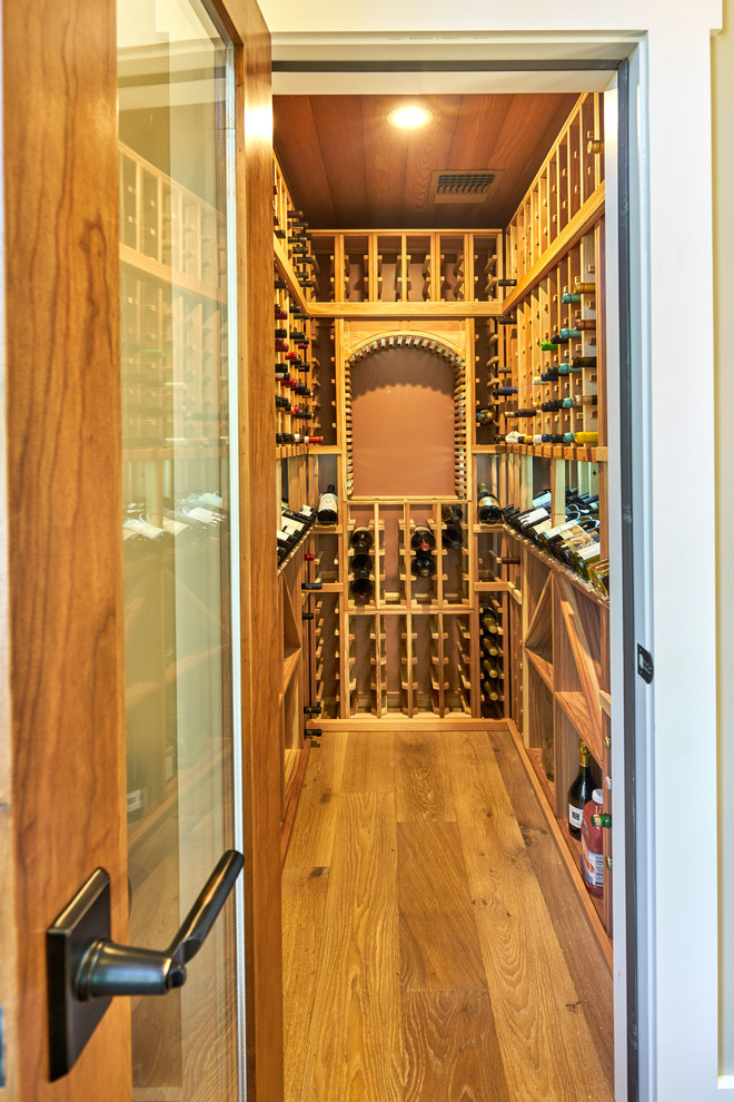 This is an example of a small transitional wine cellar in San Francisco with medium hardwood floors and storage racks.