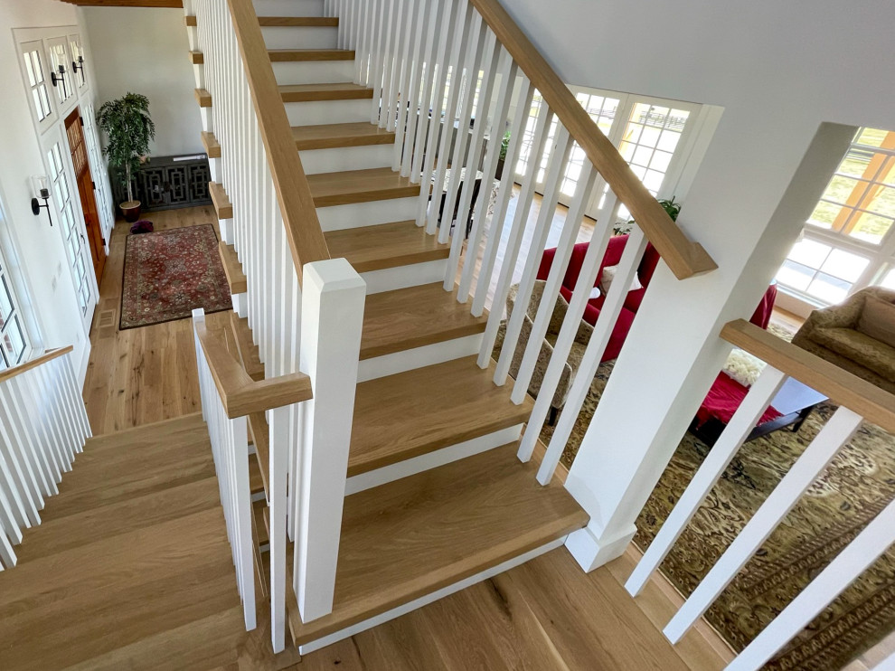 Design ideas for a mid-sized country wood u-shaped staircase in DC Metro with wood risers, wood railing and planked wall panelling.