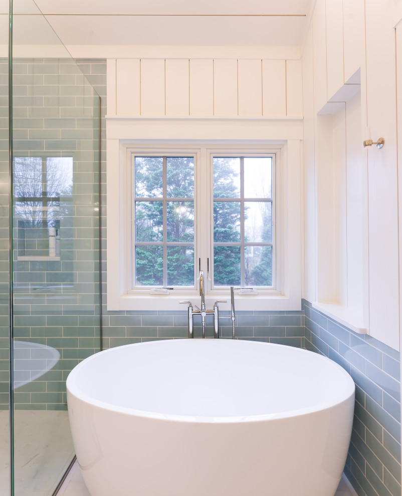 Lantlig inredning av ett mellanstort vit vitt en-suite badrum, med vita skåp, ett fristående badkar, en kantlös dusch, blå kakel, ett undermonterad handfat, bänkskiva i kvarts och dusch med gångjärnsdörr