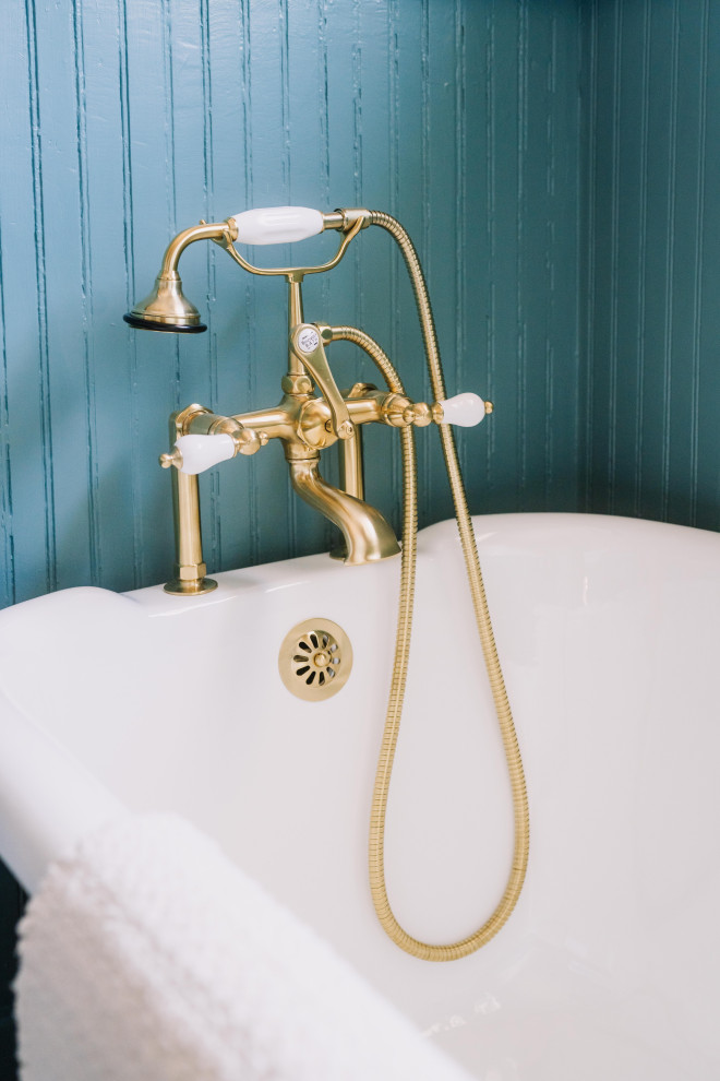 Réalisation d'une salle de bain victorienne avec une baignoire sur pieds, un mur bleu et du lambris.