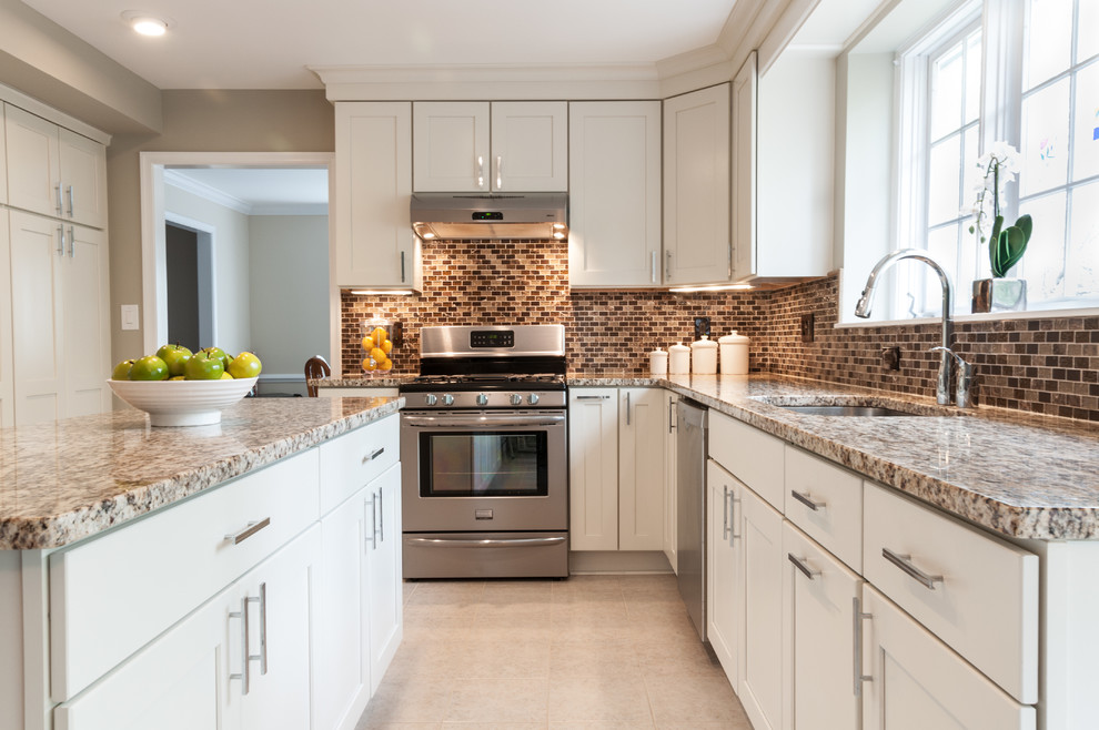 Inspiration for a large contemporary u-shaped open plan kitchen in DC Metro with stainless steel appliances, an undermount sink, shaker cabinets, white cabinets, brown splashback, granite benchtops, mosaic tile splashback, ceramic floors and with island.