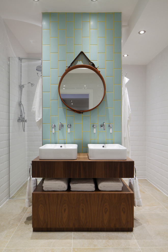 Design ideas for a contemporary bathroom in London with flat-panel cabinets, medium wood cabinets, a vessel sink and blue tile.