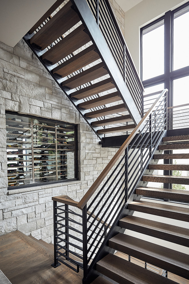 Photo of a contemporary wood u-shaped staircase in Minneapolis with open risers and cable railing.