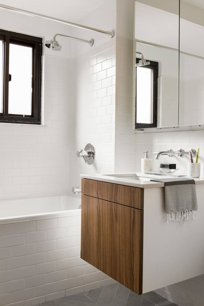 Inspiration for a contemporary bathroom in Charleston with flat-panel cabinets, medium wood cabinets, an alcove tub, a shower/bathtub combo, white tile, subway tile, white walls, an undermount sink, grey floor, a shower curtain and white benchtops.