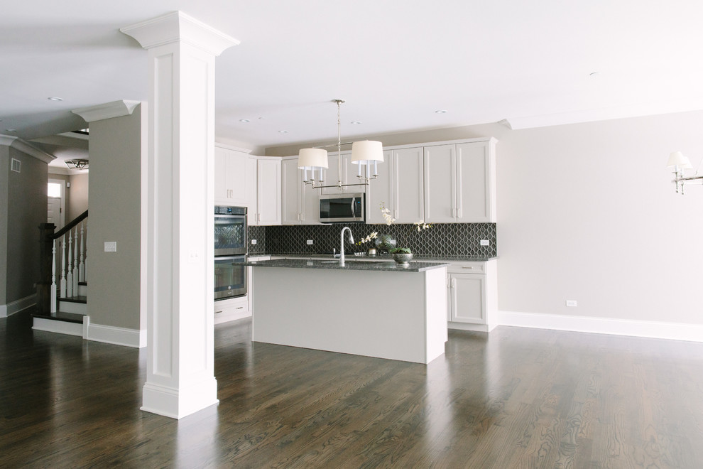 Eat-in kitchen - mid-sized transitional dark wood floor eat-in kitchen idea in Chicago with a single-bowl sink, shaker cabinets, white cabinets, granite countertops, black backsplash, glass tile backsplash, stainless steel appliances and an island