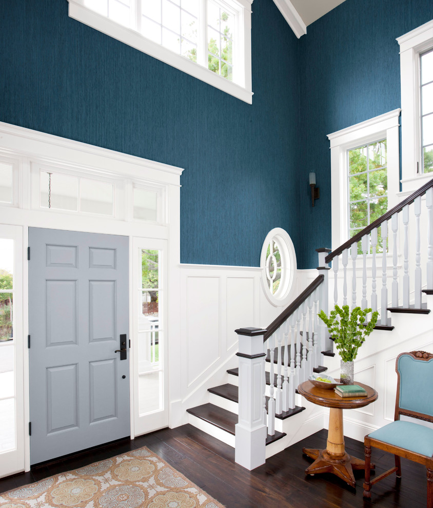 Design ideas for a large transitional foyer in Charlotte with blue walls, dark hardwood floors, a single front door and a blue front door.