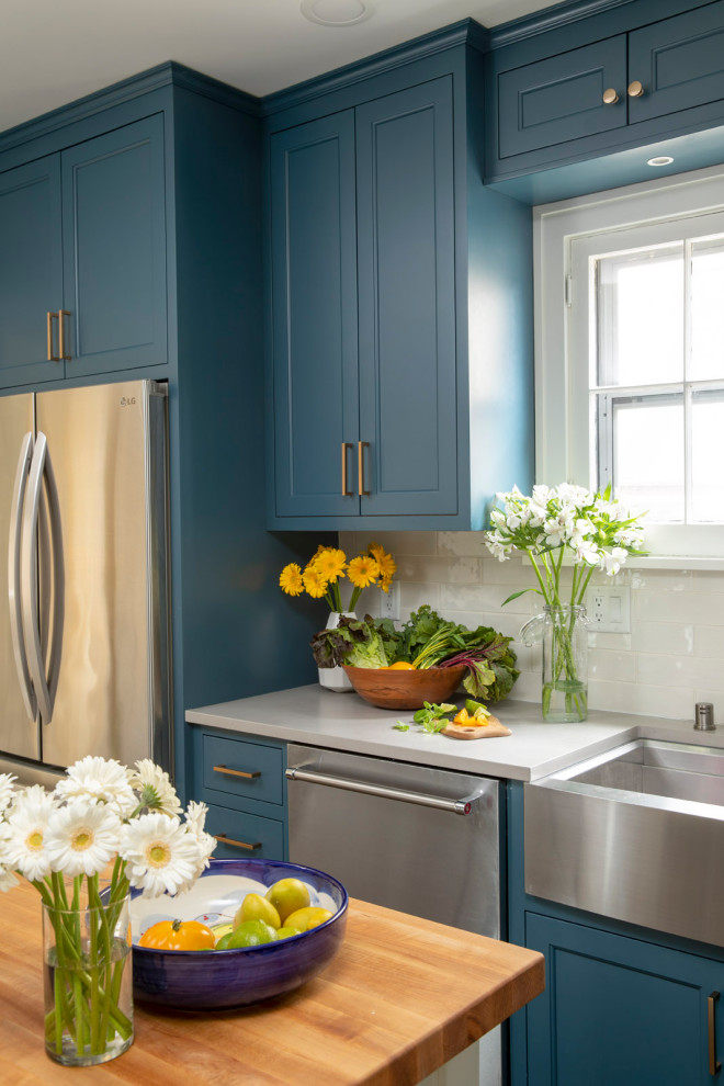 This is an example of a medium sized rural galley kitchen pantry in Minneapolis with blue cabinets, ceramic splashback, vinyl flooring, brown floors and white worktops.