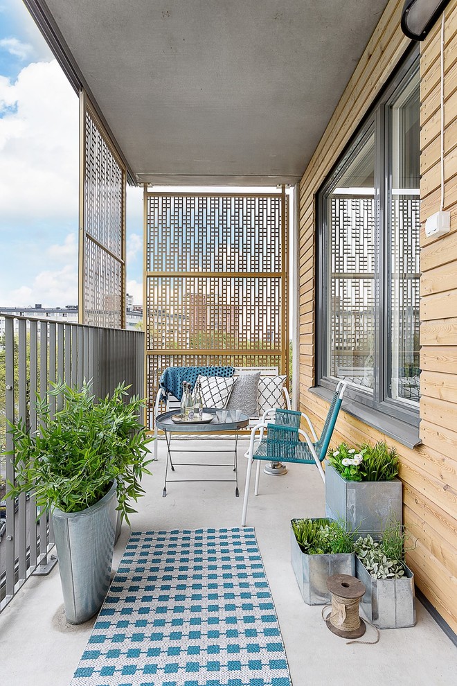 This is an example of a mid-sized scandinavian balcony in Stockholm with a roof extension.