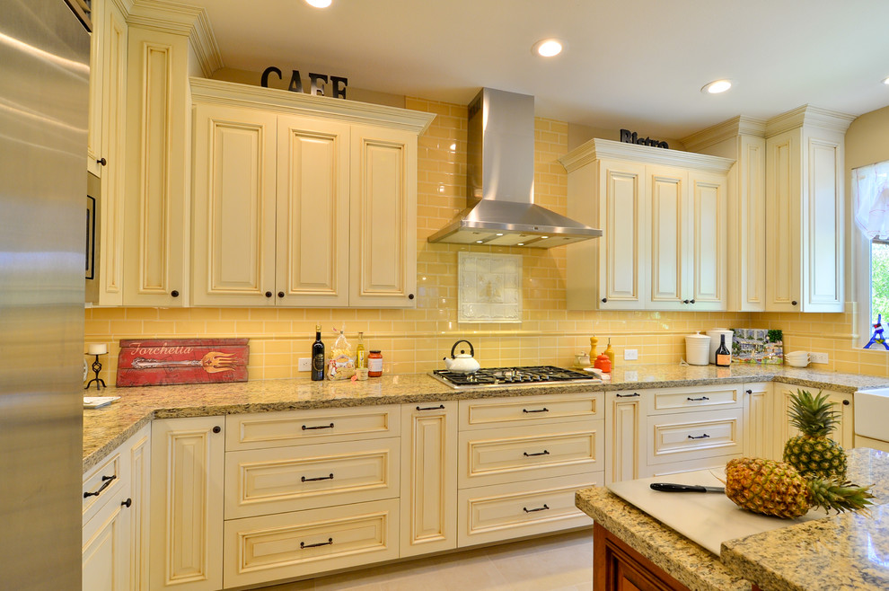 Inspiration for an expansive traditional u-shaped open plan kitchen in Tampa with a farmhouse sink, raised-panel cabinets, beige cabinets, granite benchtops, yellow splashback, ceramic splashback, stainless steel appliances, porcelain floors and with island.