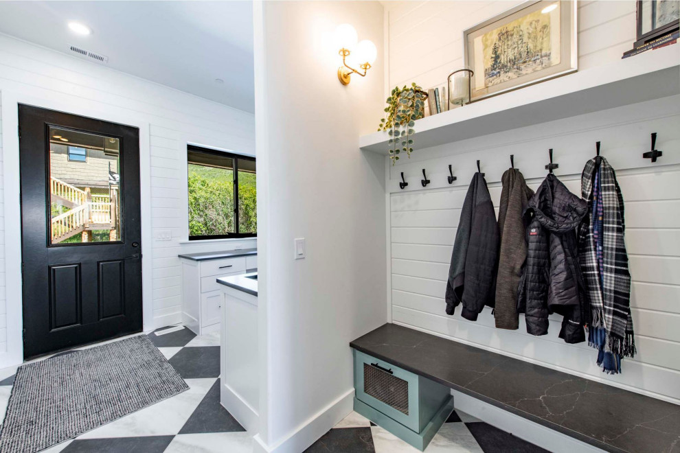 Inspiration for a large mudroom in Salt Lake City with white walls, ceramic floors, a single front door, a black front door, multi-coloured floor and planked wall panelling.