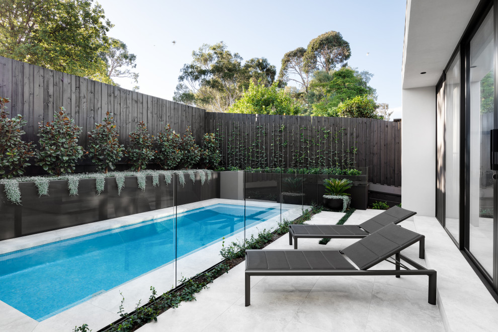 На фото: маленький прямоугольный бассейн в стиле модернизм с покрытием из плитки для на участке и в саду с