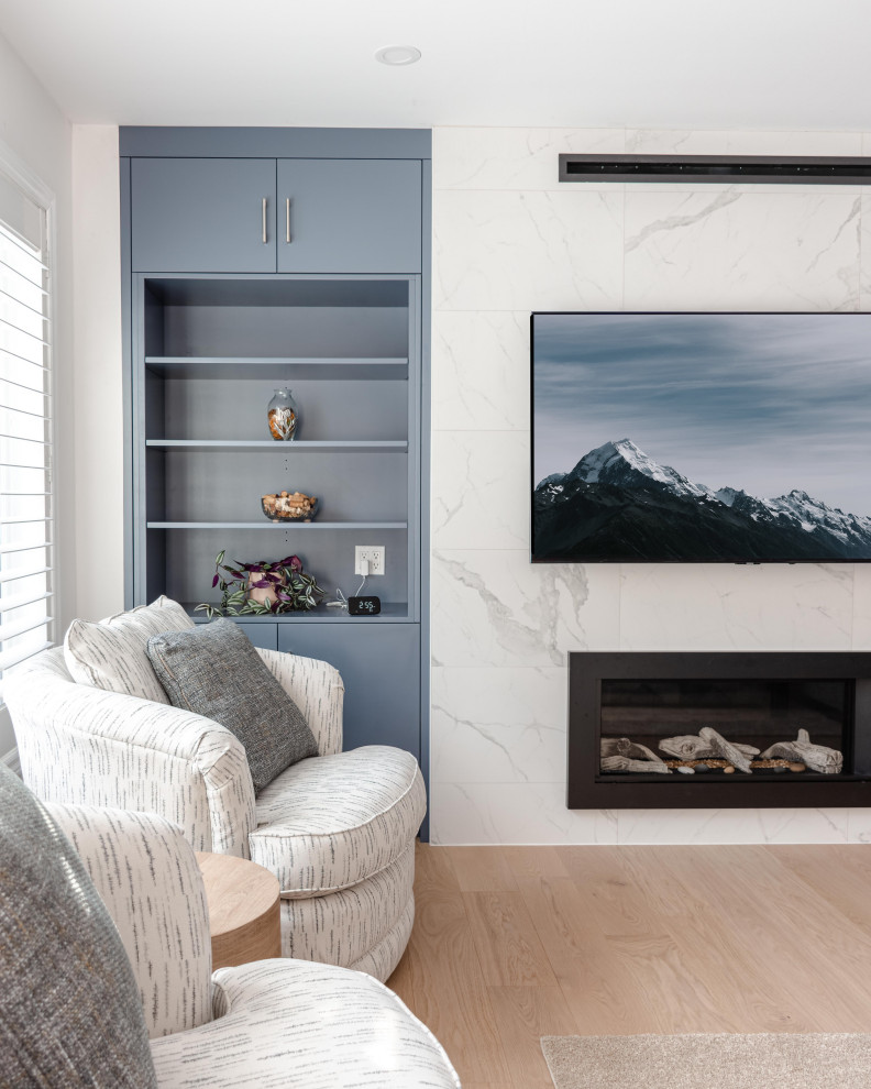 トロントにある広いトラディショナルスタイルのおしゃれなLDK (ライブラリー、白い壁、淡色無垢フローリング、標準型暖炉、タイルの暖炉まわり、壁掛け型テレビ、ベージュの床) の写真