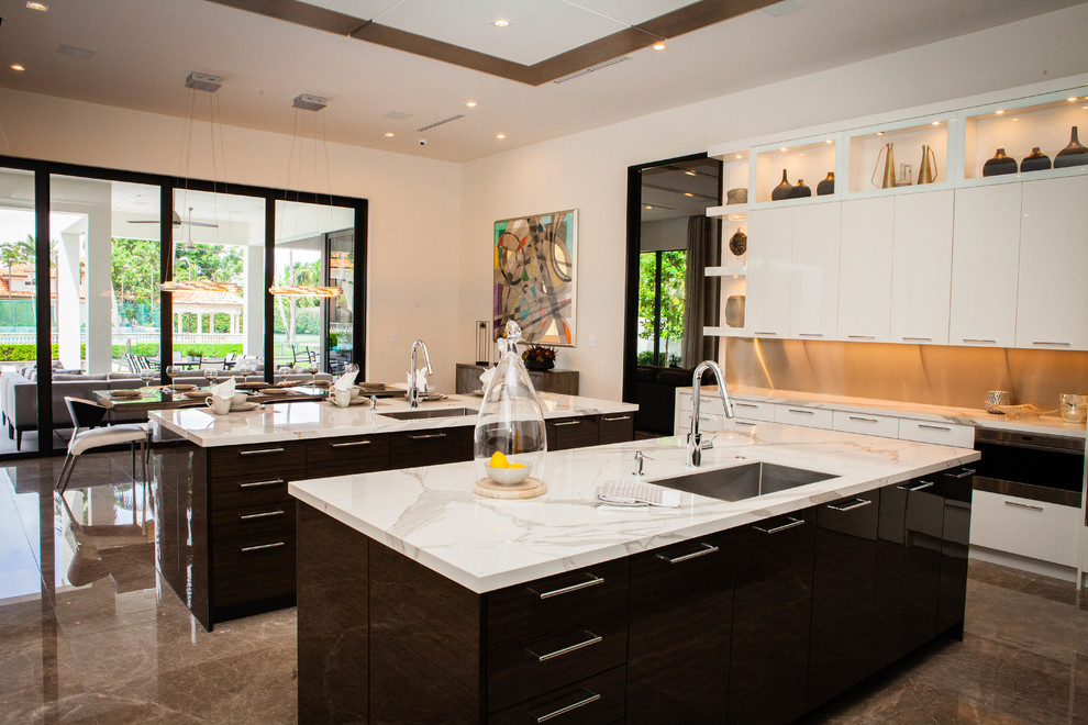 Large contemporary l-shaped eat-in kitchen in Miami with an undermount sink, flat-panel cabinets, grey splashback, stainless steel appliances, marble floors, multiple islands, brown floor, brown cabinets and white benchtop.