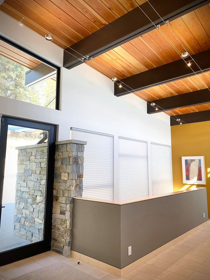 Photo of a mid-sized contemporary foyer in Other with white walls, porcelain floors, a single front door, a glass front door, beige floor and exposed beam.