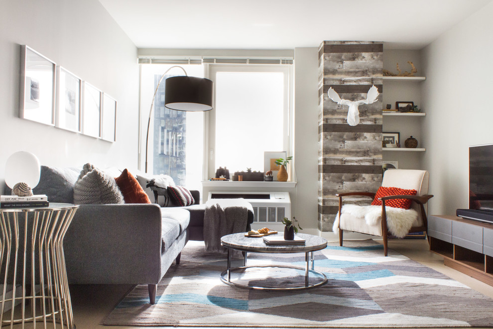 Small minimalist enclosed light wood floor and beige floor living room photo in New York with no fireplace, gray walls and a tv stand