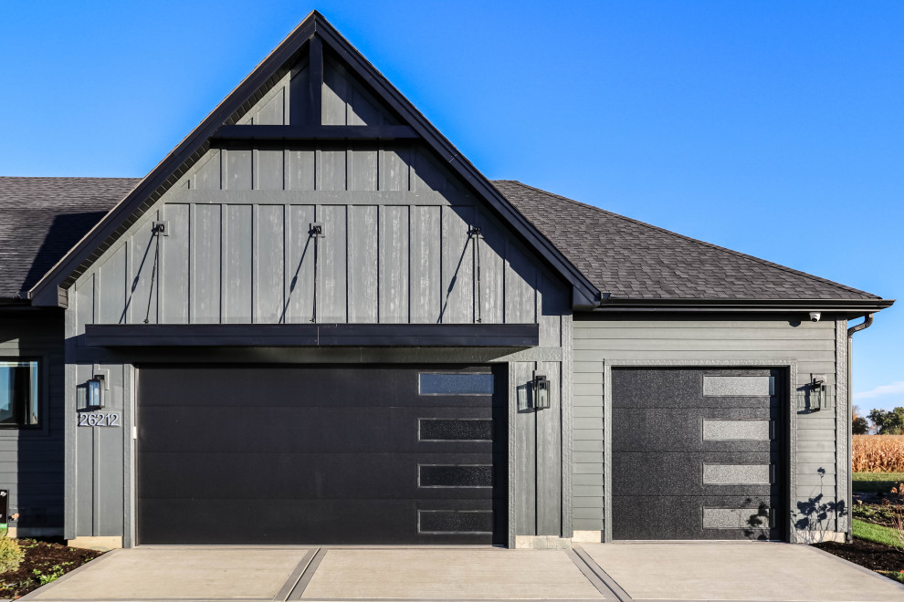 Photo of a black modern bungalow detached house in Chicago with concrete fibreboard cladding, a shingle roof, a black roof and board and batten cladding.