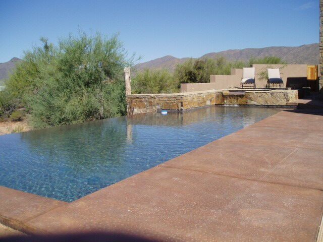 Inspiration for a mid-sized backyard brick and rectangular infinity hot tub remodel in Phoenix