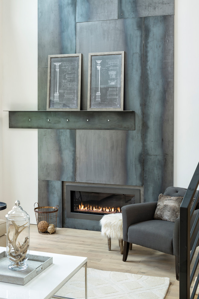 Design ideas for a mid-sized industrial open concept family room in Minneapolis with white walls, light hardwood floors, a ribbon fireplace, a metal fireplace surround, no tv and beige floor.