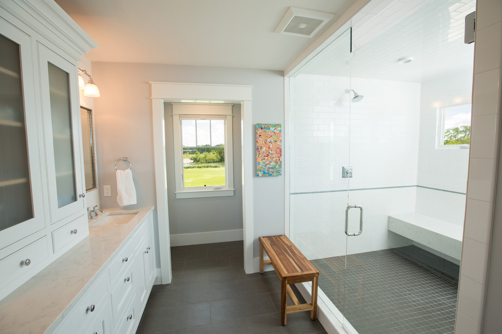 Photo of a large transitional master bathroom in Other with shaker cabinets, white cabinets, a double shower, a two-piece toilet, white tile, ceramic tile, white walls, porcelain floors, an undermount sink, engineered quartz benchtops, grey floor and a hinged shower door.