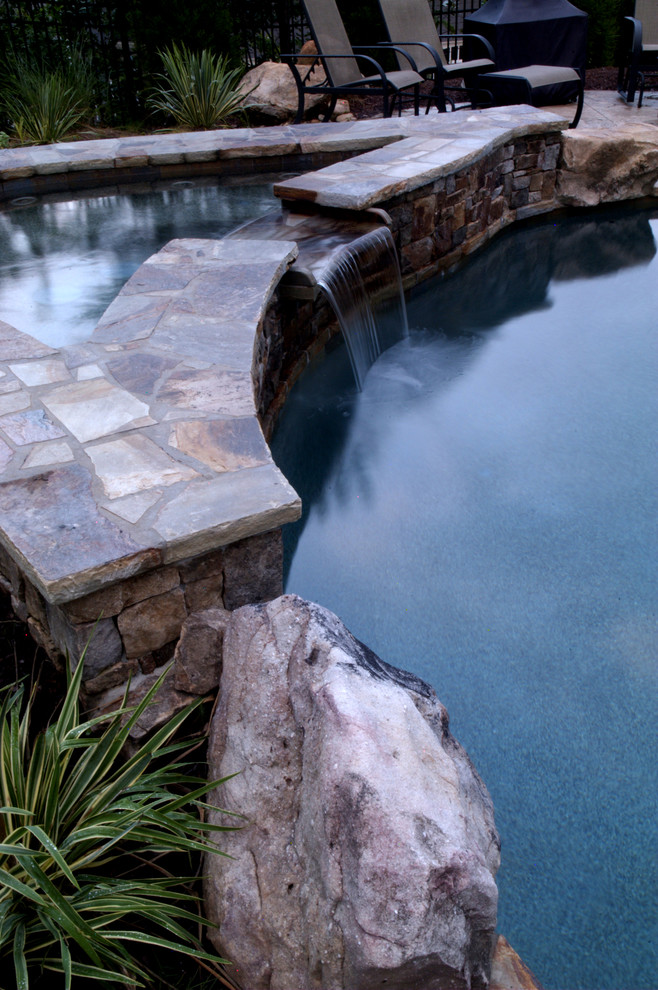 Hot tub - mid-sized rustic backyard stone and kidney-shaped hot tub idea in Atlanta