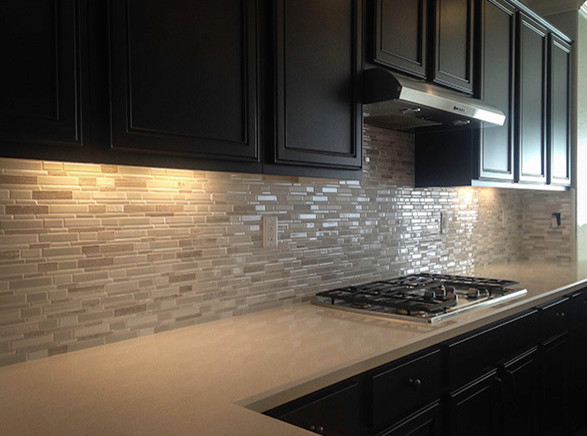 Inspiration for a large transitional l-shaped kitchen remodel in San Diego with recessed-panel cabinets, dark wood cabinets, quartz countertops, beige backsplash and stone tile backsplash