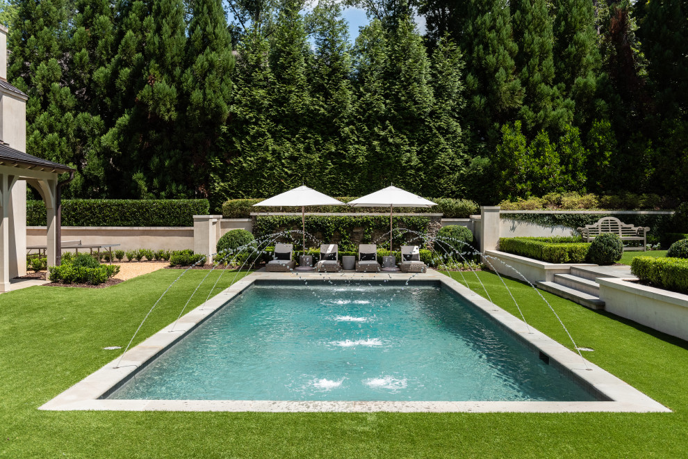 Expansive traditional back rectangular lengths swimming pool in Atlanta with a water feature and natural stone paving.