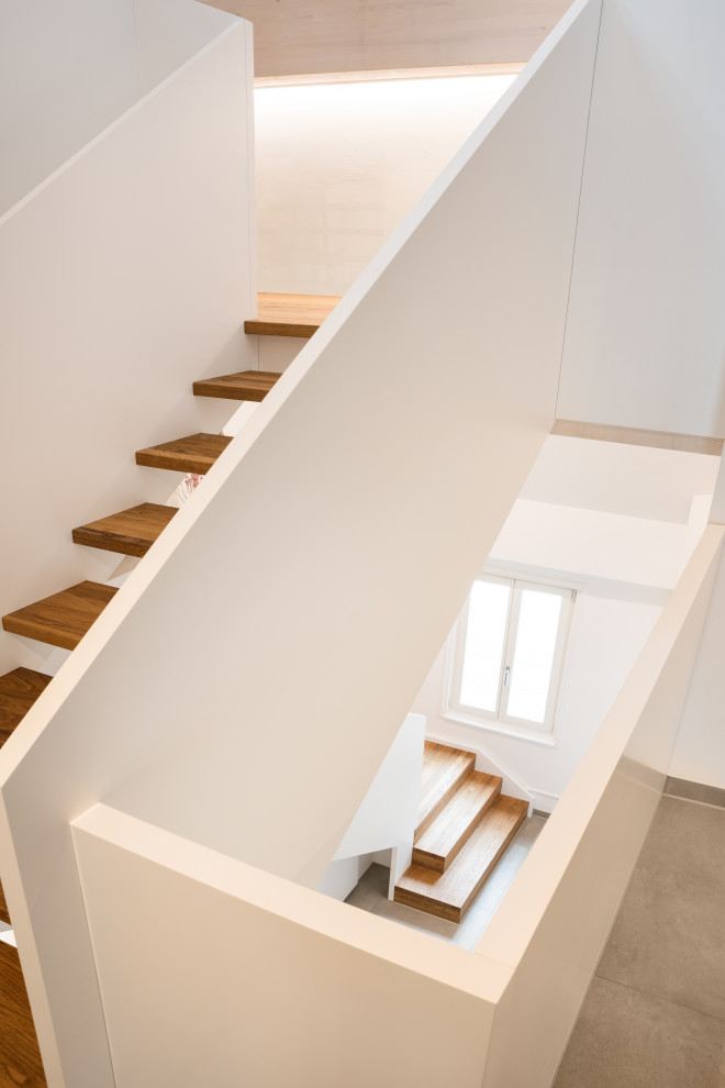 На фото: деревянная лестница в современном стиле с деревянными ступенями и деревянными перилами с