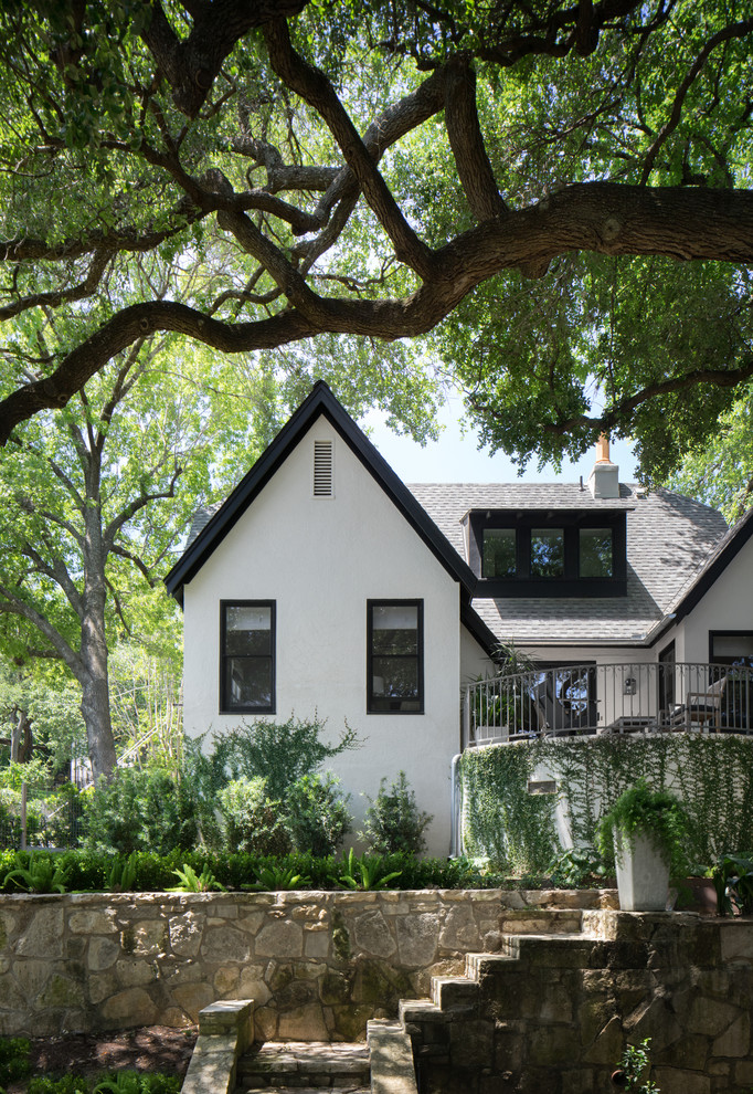 Small transitional two-storey stucco white house exterior in Austin with a shingle roof.