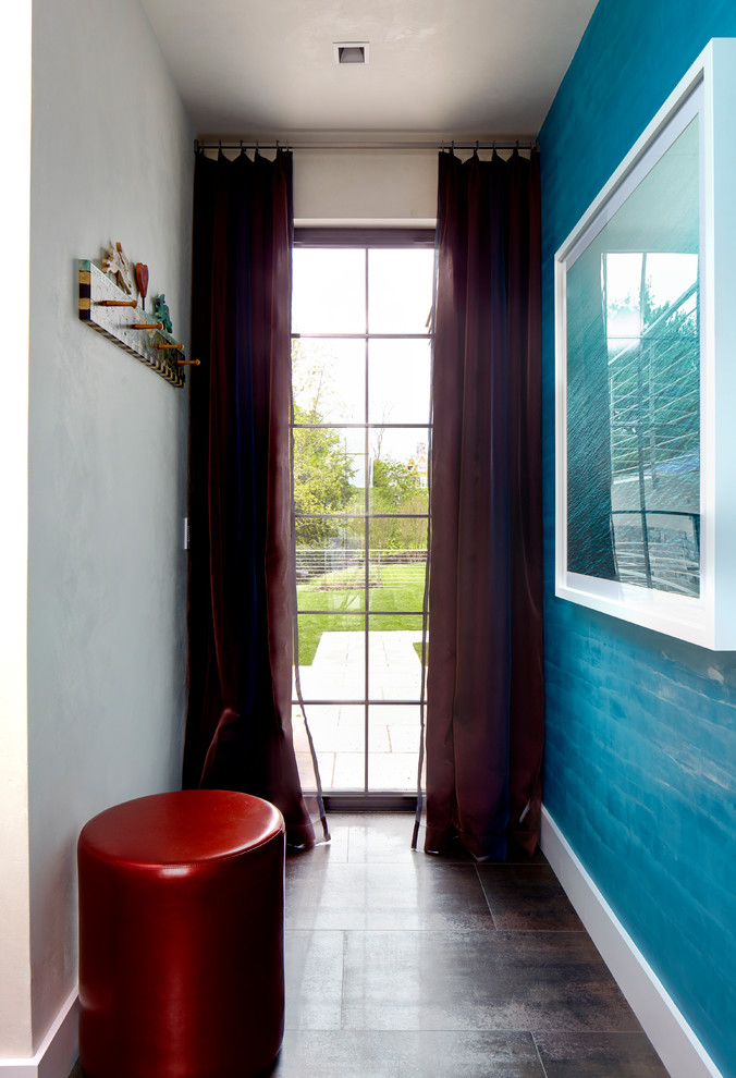 Eclectic hallway in New York with blue walls.