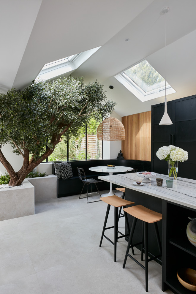 Inspiration for a large scandinavian open plan kitchen in London with a drop-in sink, flat-panel cabinets, black cabinets, quartzite benchtops, multi-coloured splashback, black appliances, with island and multi-coloured benchtop.