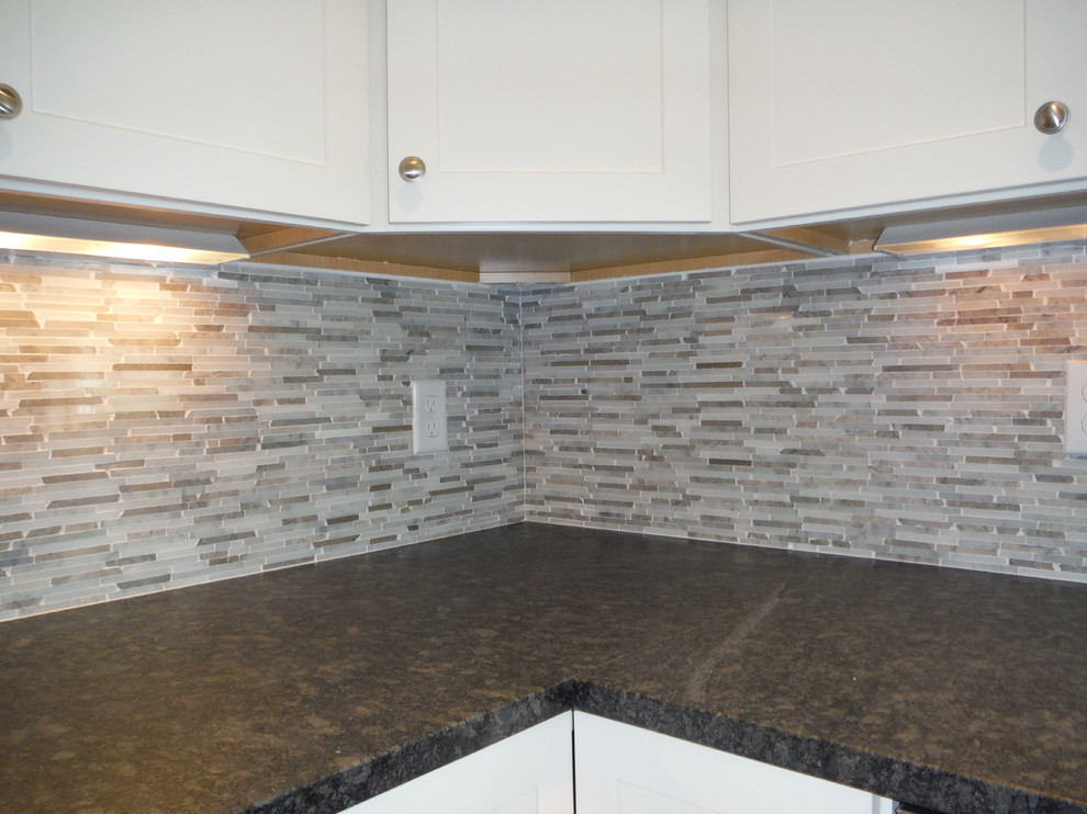 Example of a transitional kitchen design in Boston with shaker cabinets, white cabinets, granite countertops, beige backsplash, mosaic tile backsplash and no island