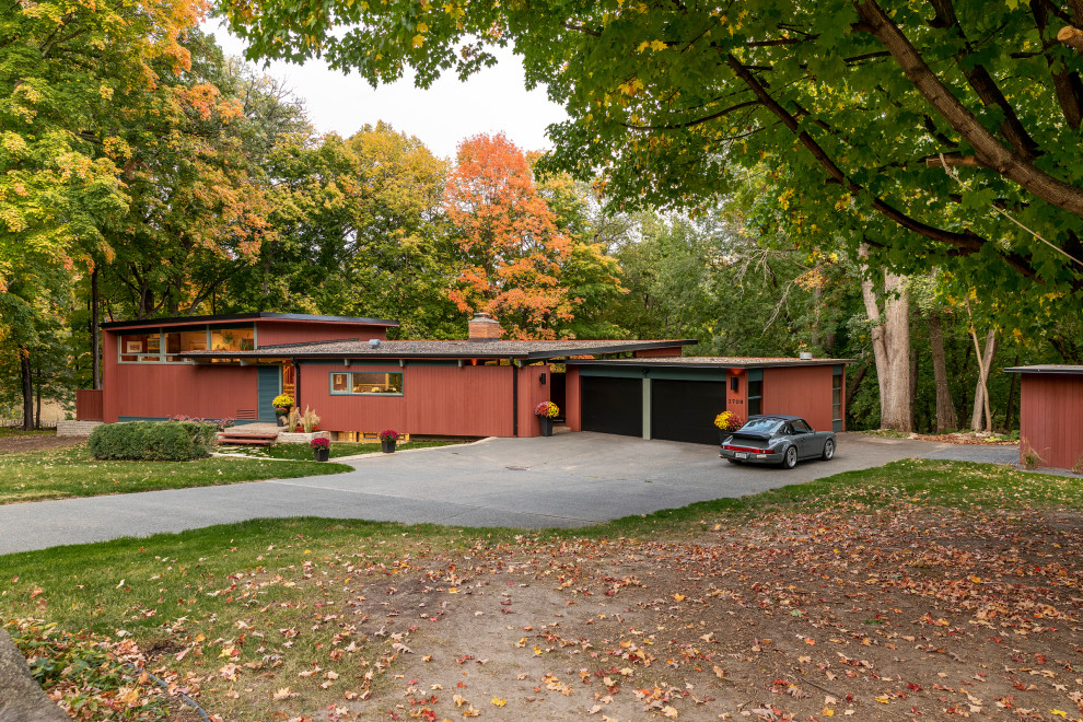 Mid-sized midcentury split-level multi-coloured house exterior in Minneapolis with wood siding and a flat roof.