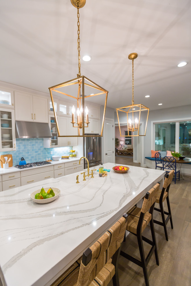 Inspiration for a large transitional l-shaped eat-in kitchen in Jacksonville with a farmhouse sink, shaker cabinets, white cabinets, quartz benchtops, blue splashback, terra-cotta splashback, stainless steel appliances, medium hardwood floors and with island.
