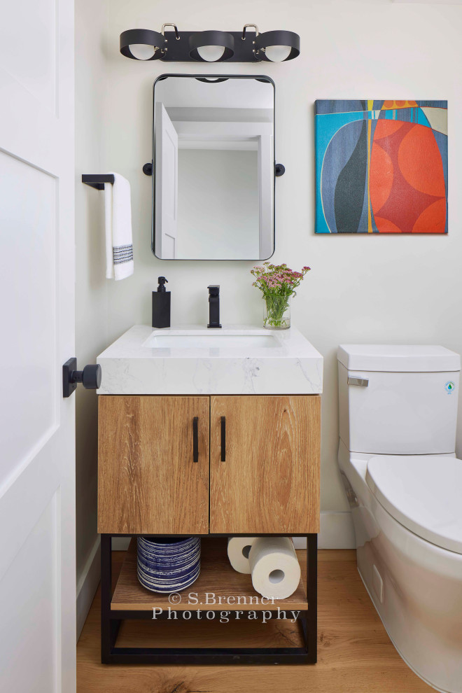 Idées déco pour un WC et toilettes industriel en bois clair avec un placard à porte plane, un mur blanc, un plan de toilette en quartz modifié, un plan de toilette blanc et meuble-lavabo sur pied.