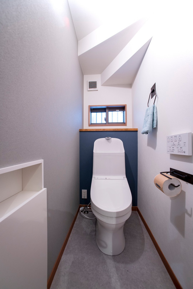 Esempio di un piccolo bagno di servizio moderno con WC monopezzo, pareti blu, pavimento in vinile, pavimento grigio, soffitto in carta da parati e carta da parati