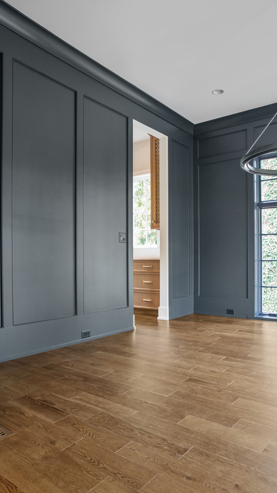 Immagine di un grande soggiorno minimalista chiuso con pareti grigie, pavimento in legno massello medio, pavimento beige e pannellatura