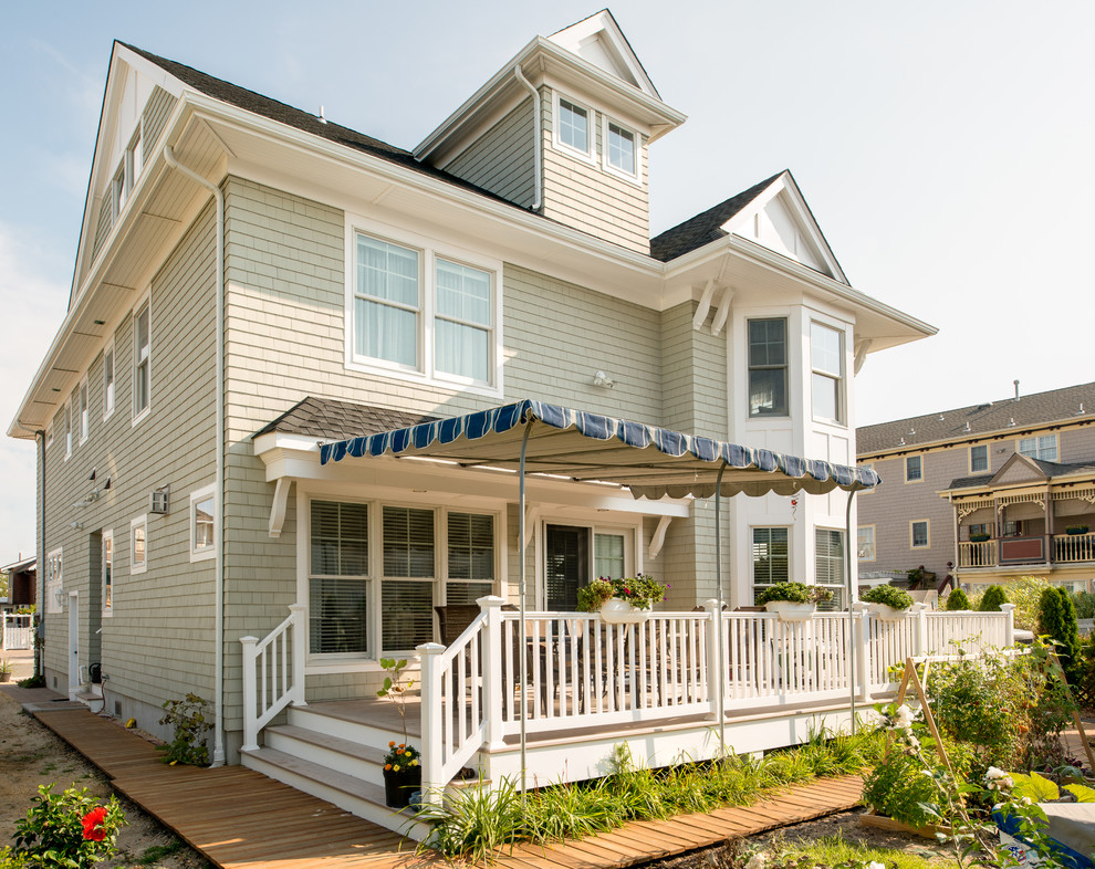 This is an example of a beach style three-storey beige exterior in New York with wood siding.