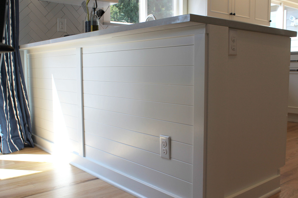 Inspiration for a mid-sized transitional u-shaped medium tone wood floor eat-in kitchen remodel in Seattle with an undermount sink, shaker cabinets, white cabinets, quartz countertops, white backsplash, ceramic backsplash, stainless steel appliances, a peninsula and gray countertops
