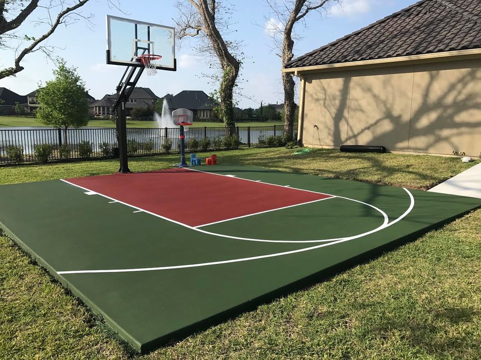 This is an example of a large traditional backyard partial sun outdoor sport court for summer in Austin with with outdoor playset and concrete pavers.