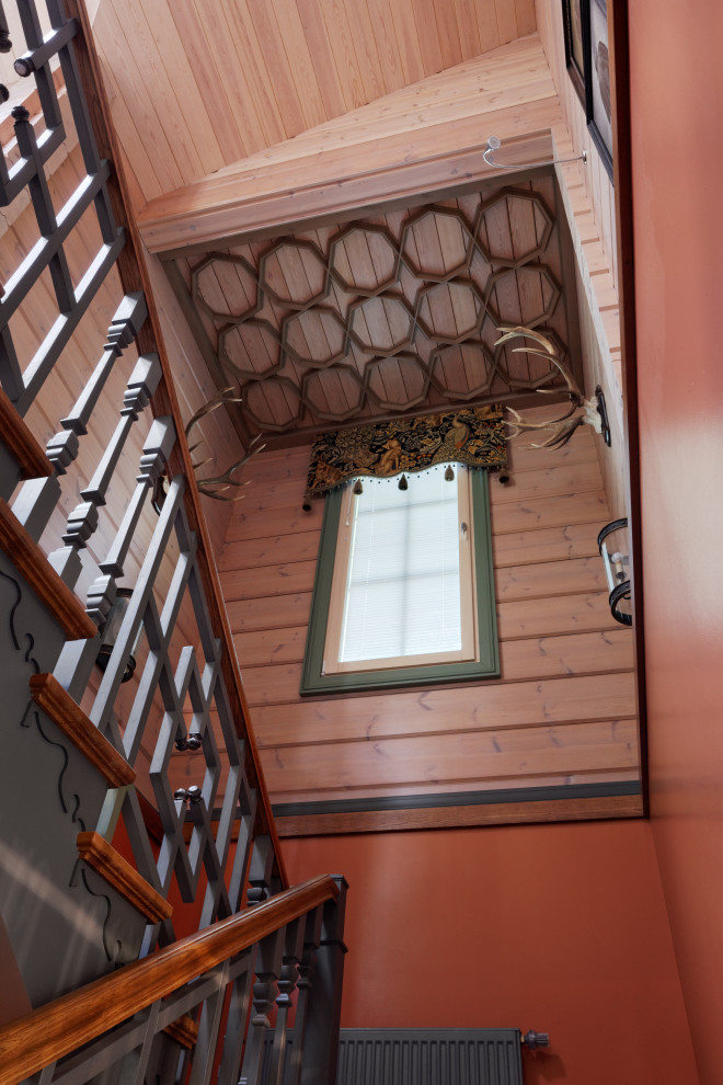 Inspiration pour un escalier bohème en U et bois de taille moyenne avec des marches en bois, des contremarches en bois et un garde-corps en bois.